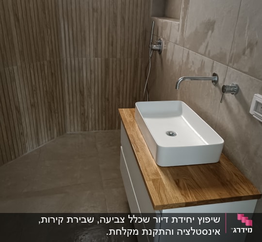 כיור לבן על משטח עץ בחדר אמבטיה מודרני